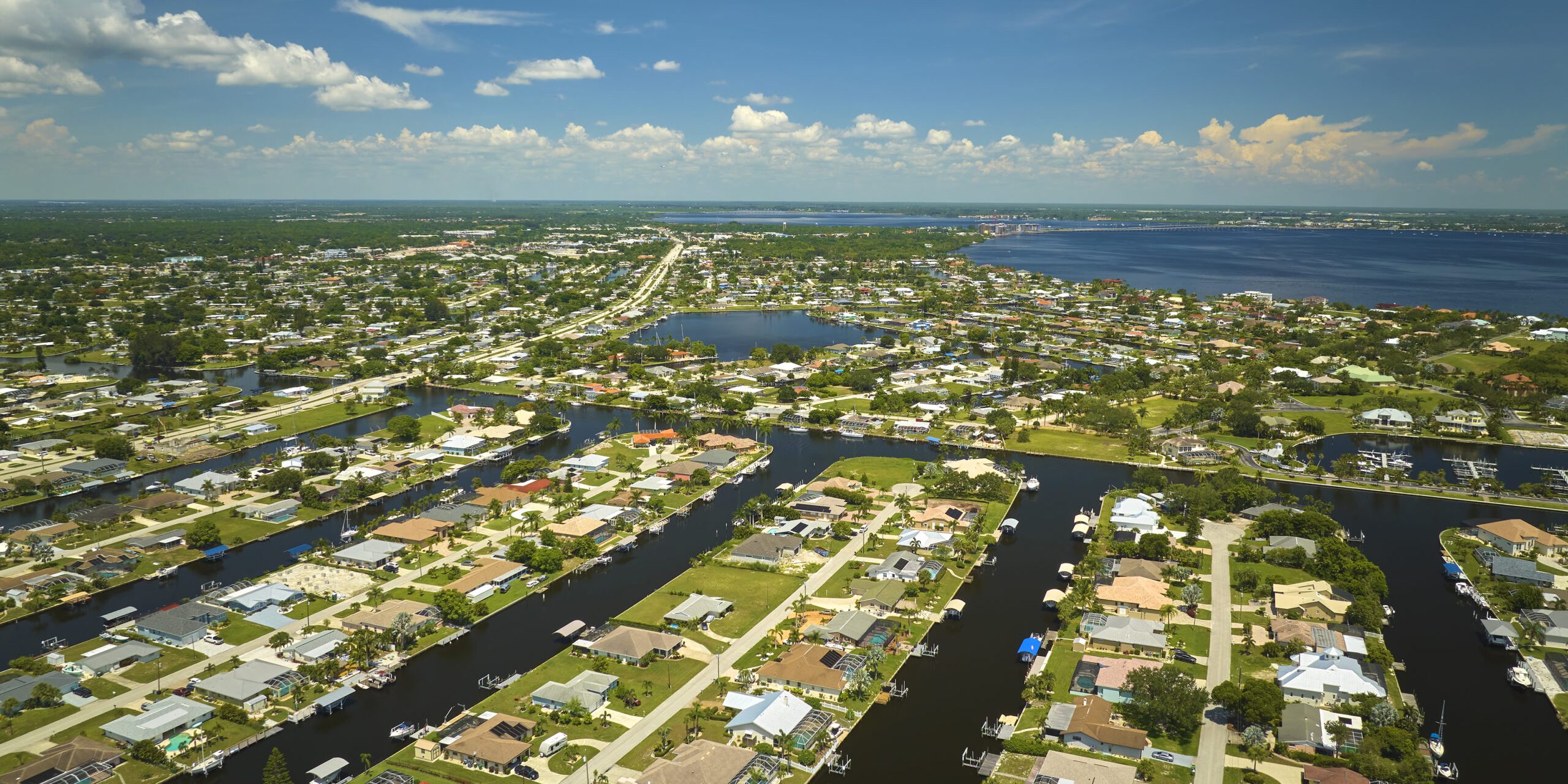 Aerial view of residential suburbs with private homes located on gulf coast near wildlife wetlands with green vegetation on sea shore. Living close to nature concept home equity lines